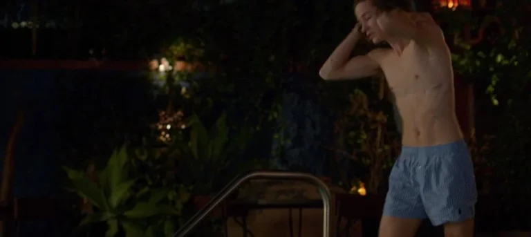 Person preparing to enter a swimming pool at night.