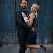 Couple posing together in formal attire.
